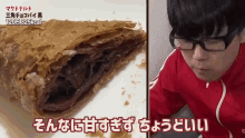 a man wearing glasses is eating a pastry that says 325kcal