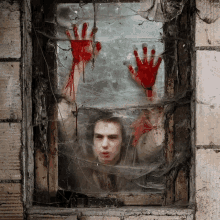 a man with bloody hands behind a glass window