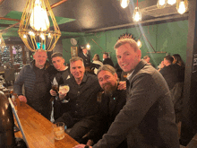 a group of men are posing for a photo in a restaurant