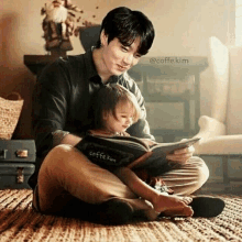 a man and a little girl are sitting on the floor reading a book together .