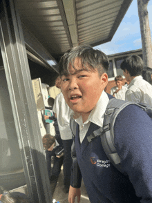 a boy wearing a sweater that says braybrook college