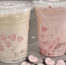 two cups of milk with hearts on them are sitting on a table .