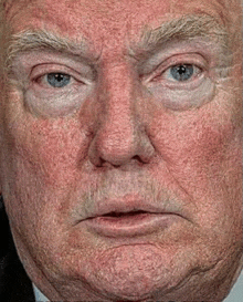 a close up of donald trump 's face with a very serious look on his face .