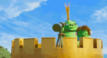 a green cartoon character looking through a telescope on top of a castle