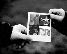 a black and white photo of a person holding a cd