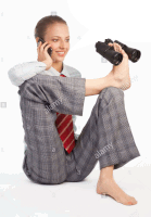 a woman in a suit and tie is sitting on the floor talking on a cell phone and looking through binoculars