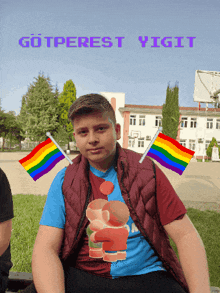 a boy with two rainbow flags on his shoulders is sitting in front of a sign that says gotperest vigitt