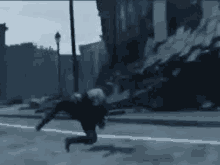 a man is running down a street in front of a building .