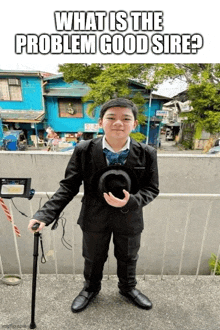 a boy in a suit holding a cane and a hat with the caption what is the problem good sire ?