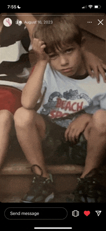 a young boy wearing a shirt that says beach on it