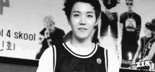 a black and white photo of a young man wearing a basketball jersey and smiling .