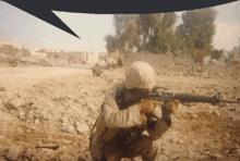 a man in a helmet is kneeling down with a gun in his hand