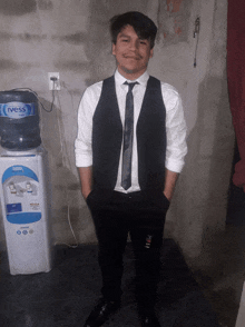 a man in a suit and tie stands in front of an ivess water cooler