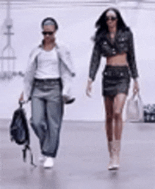 two women are walking down a street together .