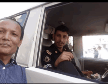 a man sitting in a car with a patch on his arm that says ' police '