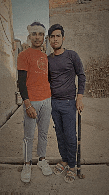 two young men posing for a picture with one wearing an orange shirt that says ' a.p.a.m. ' on it