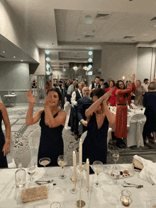 a group of people are standing around a table with candles on it