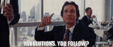 a man in a suit and tie is giving a thumbs up sign and says revolutions . you follow .