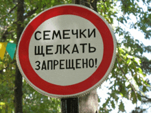 a red and white sign says " семечки " in black letters