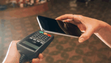 a person is using a phone to pay with a credit card machine