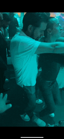 a man in a white shirt is dancing with another man in a black shirt