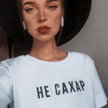 a woman wearing a white shirt that says he caxap on it