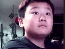 a young boy is making a funny face in front of a clock .