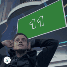 a man covering his ears in front of a sign that says 11