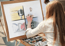 a woman is painting a picture of a microphone and the word cd