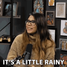 a woman sitting in front of a microphone with the words " it 's a little rainy " above her