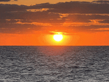 a sunset over the ocean with the sun shining brightly