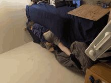 a person laying on a bed next to a wooden table with a drawing of a bird on it