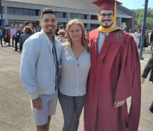 a man in a graduation cap and gown poses for a photo