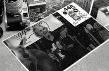 a black and white photo of a man playing a guitar next to a box of 44a professional film