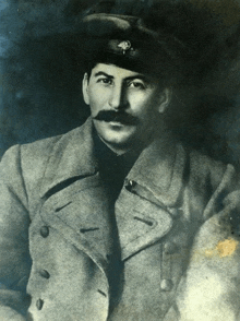 a black and white photo of a man with a mustache wearing a hat