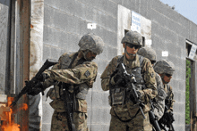 a group of soldiers are standing in front of a brick wall with a sign that says " emergency escape route "