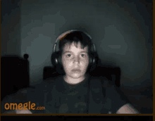 a boy wearing headphones is on a video call on omegle.com