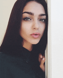 a close up of a woman 's face with a ring on her finger