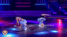 a couple of dancers on a stage with eltrece written on the bottom