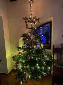 a christmas tree with decorations and lights is in a room