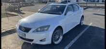 a white lexus is parked in a parking lot with a license plate that says rn 8082