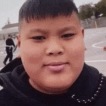 a close up of a boy 's face with a pink lip .