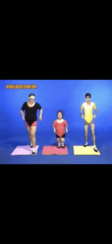 a group of people are doing exercises on yoga mats .