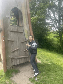 a woman climbs a wooden tower with a ladder