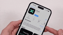 a person is holding a cellphone with the app xportal on the screen