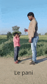 a man standing next to a little boy drinking from a bottle with the word le pani written below him