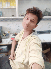 a young man taking a selfie in front of a shelf with cigarettes