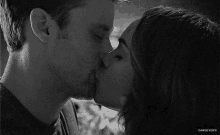 a black and white photo of a man and a woman kissing with the caption danseygifs