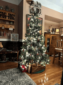 a christmas tree in a living room with a santa sign above it