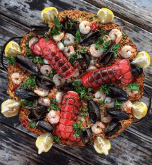 a seafood paella with lobster shrimp mussels and lemon slices